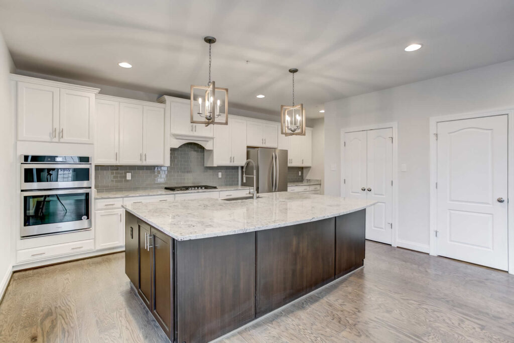 Beautiful staged kitchen with white appliances and white marble island.